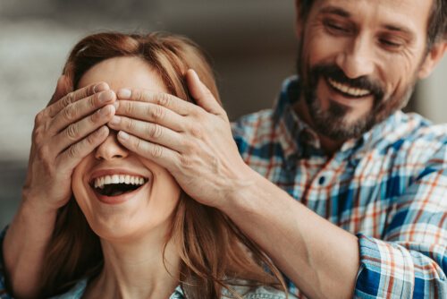 Hombre tapando ojos a su mujer
