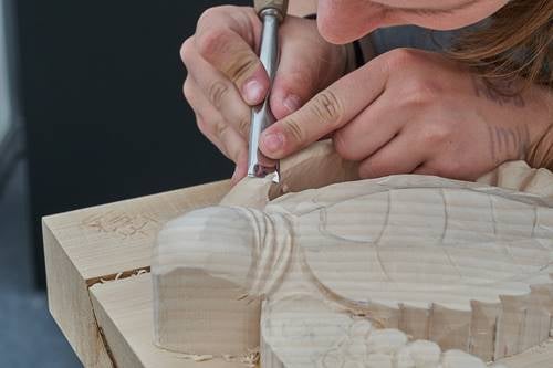 Mujer tallando madera
