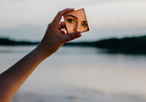 Kobieta patrząca w lustro z powodu nadmiernej samooceny