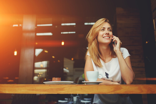 Mujer sonriendo mientras toma un café