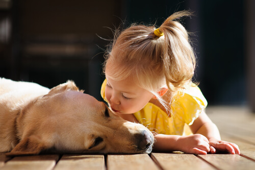 Niña dando un beso a un perro