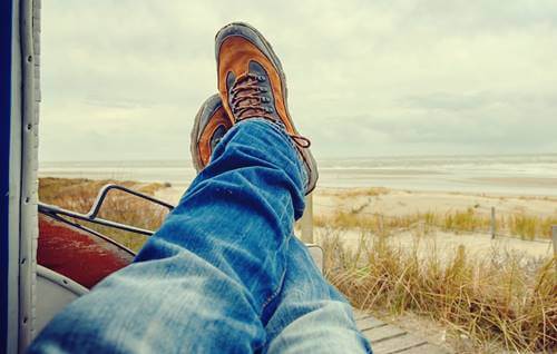 persona con pies cruzados intentando perder el tiempo