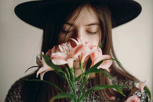 Chica oliendo flores