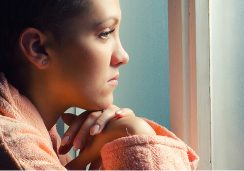Mujer con cáncer mirando por la ventana