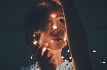 Mujer con luces representando la felicidad sintética