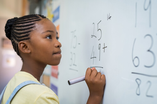 Niña africana escribiendo en una pizarra