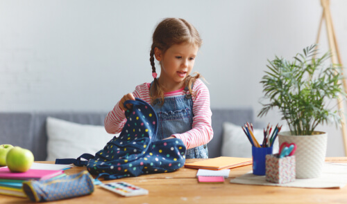 Niña sacando cosas de su mochila