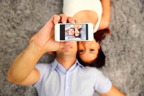 Par som tar en selfie som representerer forskjellene mellom menn og kvinner