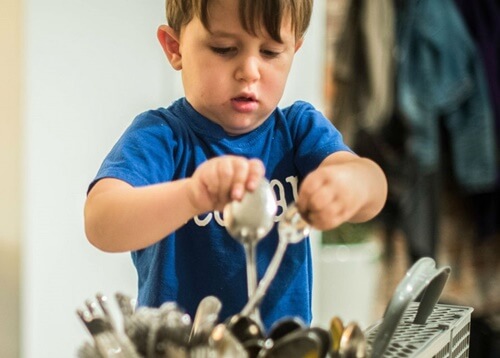 Niño limpiando los cubiertos