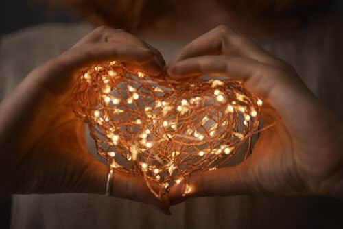 manos con corazón de luces simbolizando la admiración en la pareja