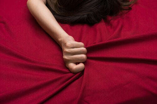 Mujer agarrando sábana roja