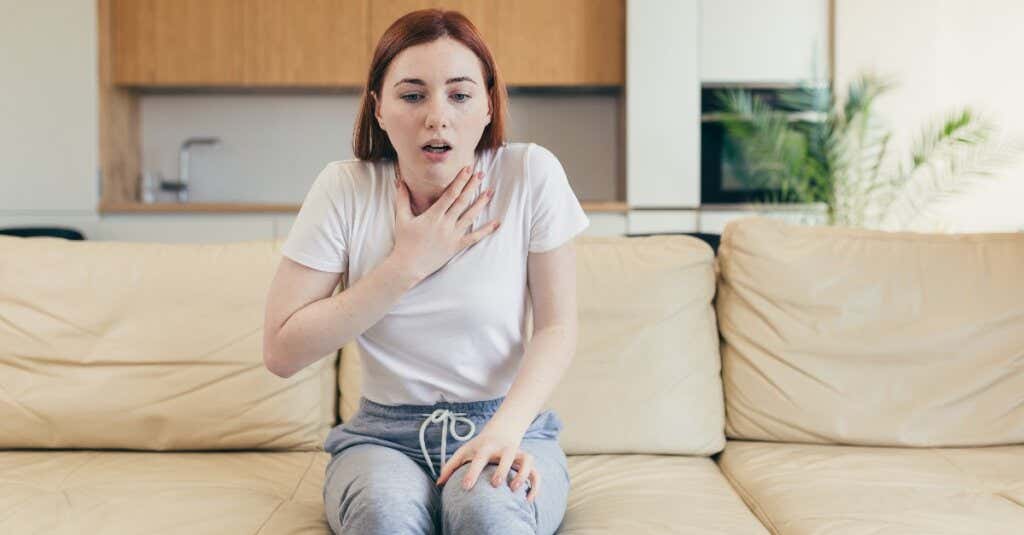 Mujer sintiendo pinchazos en el corazón por un ataque de pánico.