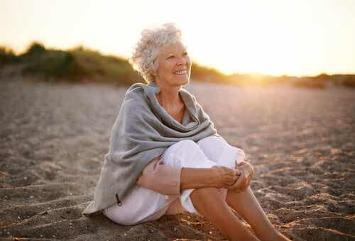 Mujer jubilada sentada en la playa