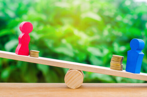 Figuras de un hombre y una mujer con dinero para representar la brecha de género