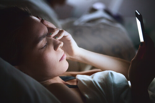 Mujer en la cama con el teléfono