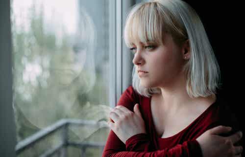 Mujer con esquizofrenia mirando por la ventana