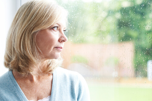 Femme triste regardant par la fenêtre