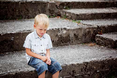 Niño llorando sentado en una escalera