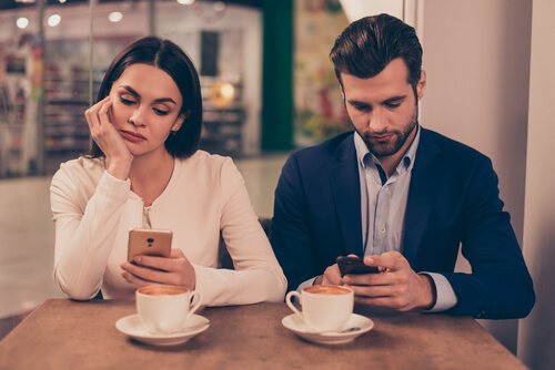 Pareja mirando sus móviles