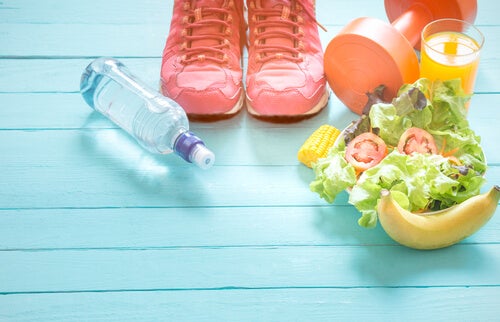 Comida sana con agua y zapatillas de deporte para representas los hábitos de vida saludables