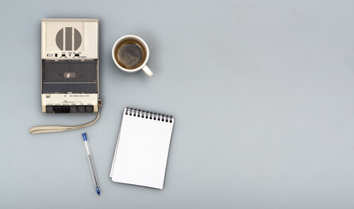 Grabadora con un café y una libreta