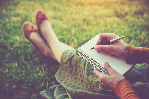 Woman writing outdoors