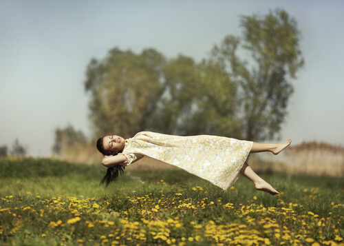 Chica levitando en el campo