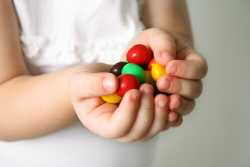 Niña con caramelos en las manos