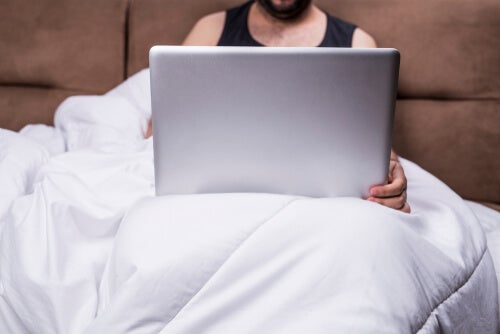 Hombre en la cama con un ordenador