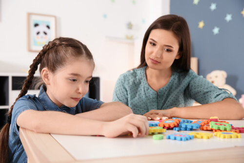 Niña con autismo con una psicóloga representando a los niños con autismo durante la crisis del coronavirus