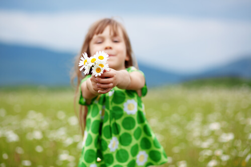 Niña con flores en las manos representando el representando el valor de la convivencia