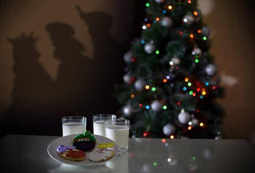 Vasos de leches con galletas al lado del árbol de Navidad