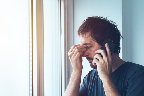 Hombre con angustia mientras habla por teléfono