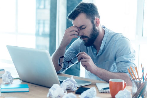 Stressed man at work thinking that he can't concentrate