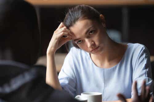 Mujer aburrida hablando con un amigo que aplica el razonamiento motivado