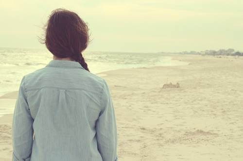 Mujer frente al mar pensando en e entrenar al cerebro para mantener la esperanza
