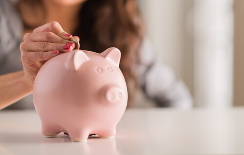 Mujer guardando el dinero en una hucha