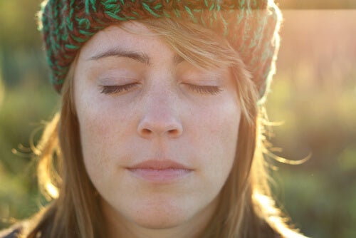 Kvinne med lukkede øyne som utfører rosinøvelse