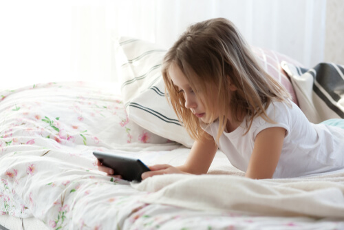 Niña con la tablet en la cama