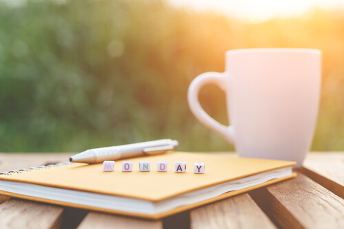 Taza de café junto a libreta