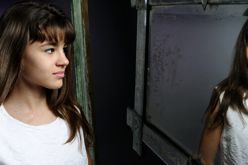 Chica adolescente mirándose al espejo