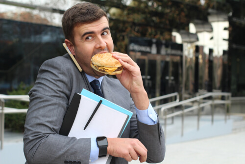 Hombre estresado comiendo