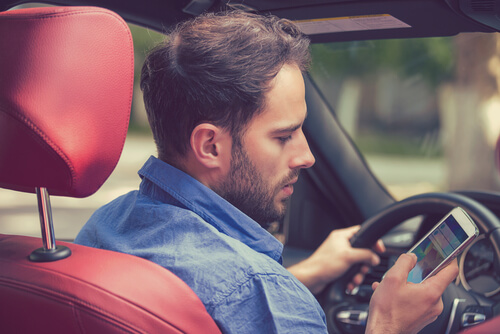 Hombre conduciendo con el móvil