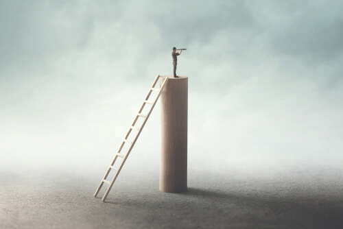 Hombre subido en un bloque mirando hacia el futuro