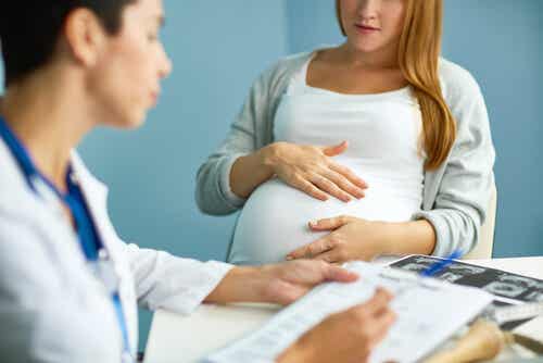 Mujer embarazada en el médico hablando sobre episiotomía