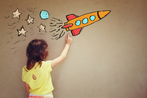 Niña mirando el dibujo de un cohete