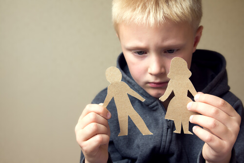 Niño sujetando dos figuras de cartón