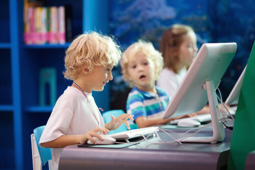 Crianças com computadores em classe