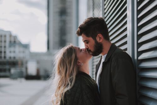 Pareja dándose un beso en la calle