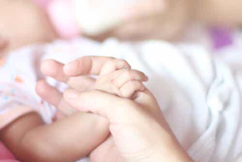 Madre sujetando la mano del bebé